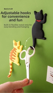 Detail of flexible cat-shaped magnetic hook showing bendable legs holding scissors