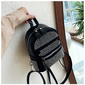 Detalle de mini mochila de cuero PU negro con remaches plateados a la mano