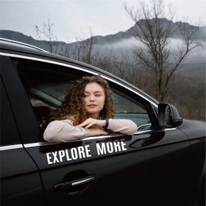 Outdoor lifestyle scene of a model leaning against a car with 'EXPLORE MORE' text
