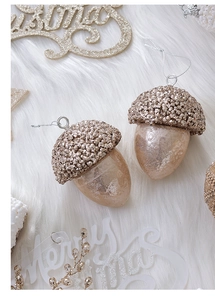 Champagne gold acorn Christmas ornaments with glitter caps on soft white faux fur