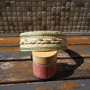 Detail of bohemian raffia headband with twisted straw weave in beige and green