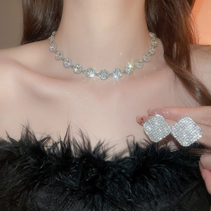Dettaglio di un set di gioielli quadrati d'argento indossati da una modella in stile lusso