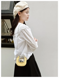 Mini yellow PU leather crossbody bag with silver metal handle shown on model