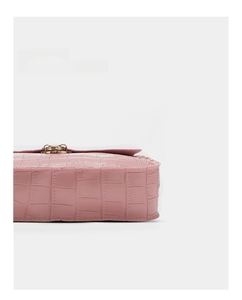 Detail of pink faux crocodile leather texture and golden metal clasp on a small square bag