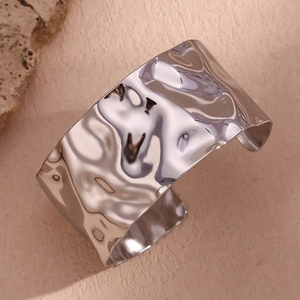 Macro detail of wide hammered texture open cuff bracelet in polished silver finish