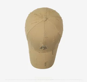 Overhead view of khaki distressed baseball cap with ripped details and embroidered logo
