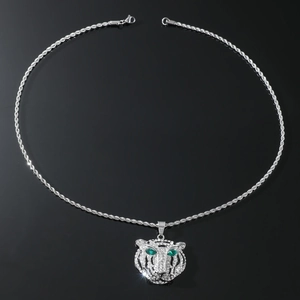Macro view of iced out lion head pendant with green eyes and twisted rope chain