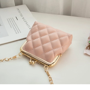 Detail of pink quilted mini crossbody bag with golden kiss-lock and chain strap