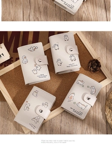 Detail view of cream PU leather card holder with cute animal prints and metal snap button