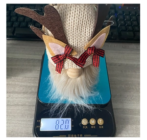 Detailed view of handmade knitted Christmas gnome reindeer weighing 82.0g on digital scale