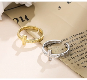 Detail view of gold and silver S925 cross rings with unique irregular wrinkled texture