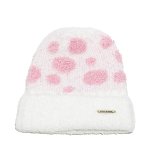 Detail of soft plush knitted beanie with pink polka dots and metal brand tag