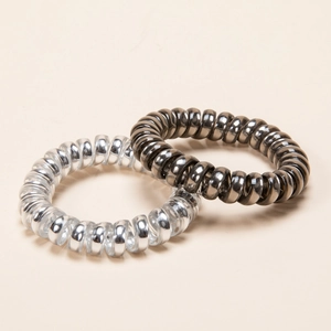 Metallic spiral telephone wire hair ties in silver and dark grey displayed at a 45-degree angle