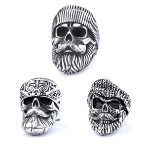 Three vintage punk skull rings in distressed silver finish for men on white background