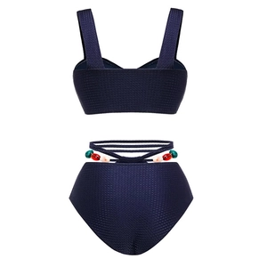 Detail view of navy blue high-waisted bikini with textured fabric and colorful side beads