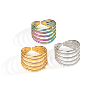 Tre anelli aperti multistrato in oro, argento e finiture iridescenti su sfondo bianco
