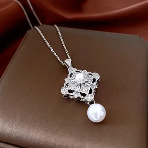 Elegant silver pendant necklace with zircon flower and pearl on a luxury brown display