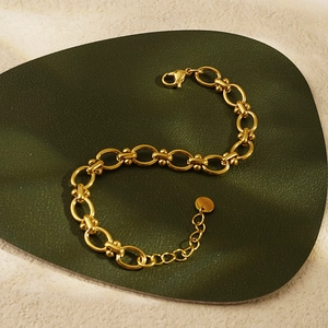 Detailed view of the gold oval link chain bracelet with adjustable lobster clasp closure