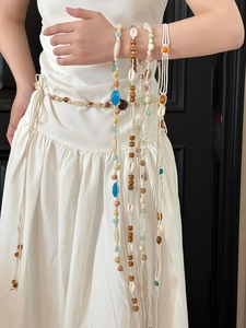 Détail de la chaîne de taille tissée à la main avec perles en bois et coquillages