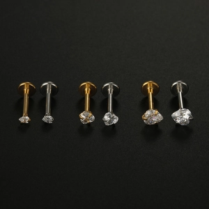 Macro detail of heart-shaped zircon lip studs in three sizes and two metallic finishes