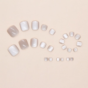 Macro detail of 24 pearl white cat-eye press-on toenails showing shimmering magnetic texture