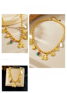 Detail of vintage gold bead necklace with cherry skull charms and baroque pearl accents