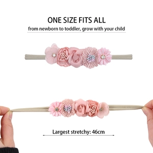 Detail of pink flower headband showing stretchable nylon band for newborns to toddlers
