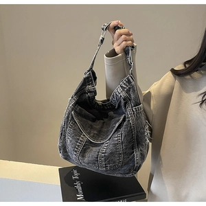 Détail d'un sac cabas en denim délavé vintage avec coutures et boucle métallique