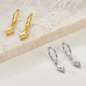 Detail of gold and silver S925 geometric hoop earrings with crystal rhombic pendants