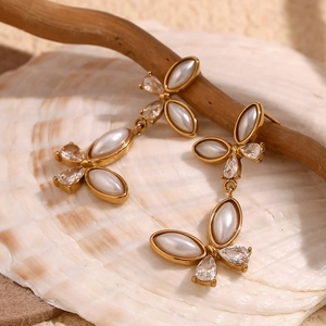 Detail of 18K gold butterfly earrings with white pearls and sparkling zircon stones