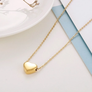 Dettaglio di una collana con ciondolo a cuore placcata oro 14k con catena sottile su bianco