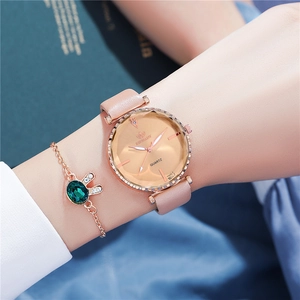 Detail of rose gold ladies watch with pink leather strap and emerald rabbit bracelet