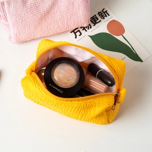 Macro view of wave texture cosmetic bags in yellow and pink showing large capacity