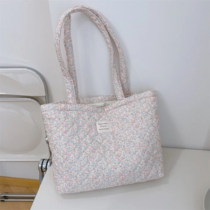 Détail du sac fourre-tout fleuri avec surpiqûres en losanges et étiquette tissée