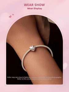 Detail of S925 silver heart charm with pink enamel flower on a mesh bracelet