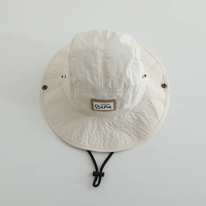 Close-up of beige quick-dry bucket hat with bear patch, vent holes and windproof cord