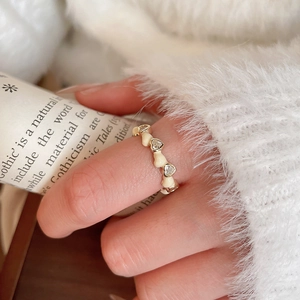 Détail macro d'une bague coeur plaquée or 14k avec zircons sur un fond en peluche douce