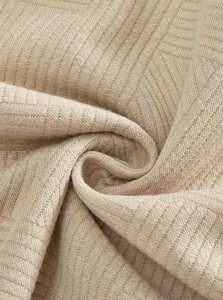 Detailed macro view of khaki knitted fabric showing fine jacquard texture and drape