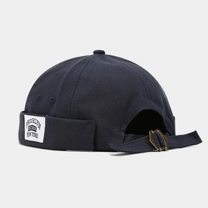 Detailed macro view of navy blue canvas beanie with vintage Brooklyn woven label and metal buckle