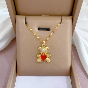 Golden titanium steel teddy bear necklace with red heart zircon in a beige jewelry box