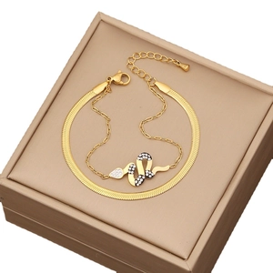 Elegantes goldenes Set aus Schlangenarmband und Schlangenkette auf Schmuckschatulle