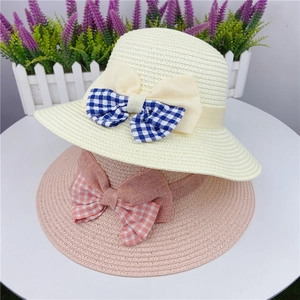 Close-up of hand-woven sun hats featuring elegant plaid bowknot details in soft beige and pink