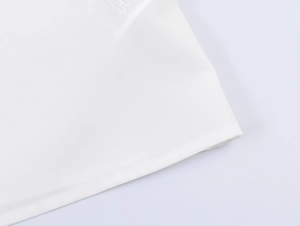 Close-up of the hemline on a white sleeveless shirt showing fine fabric texture and stitching