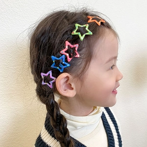 Detailed view of colorful polka dot star hair clips worn by a young girl model