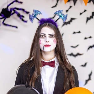 Detail of Halloween purple feather headband with laser blue bat wings on a model