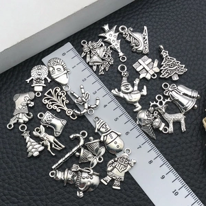 Macro detail of various Christmas themed DIY metal charms shown against a measuring ruler