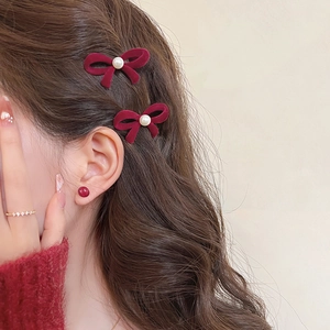 Elegant burgundy velvet bow hair clips with pearls and matching stud earrings on model