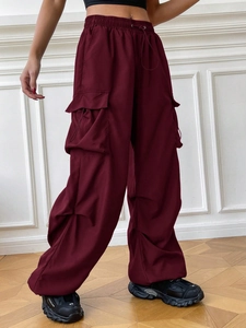 Detail view of burgundy cargo pants featuring elastic waist with functional drawstrings