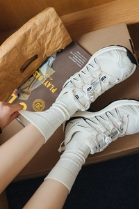 Close-up of white breathable sports socks paired with mesh trail running shoes