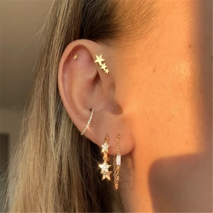 Detailed view of sterling silver star earrings and tassel chain pearls worn on ear
